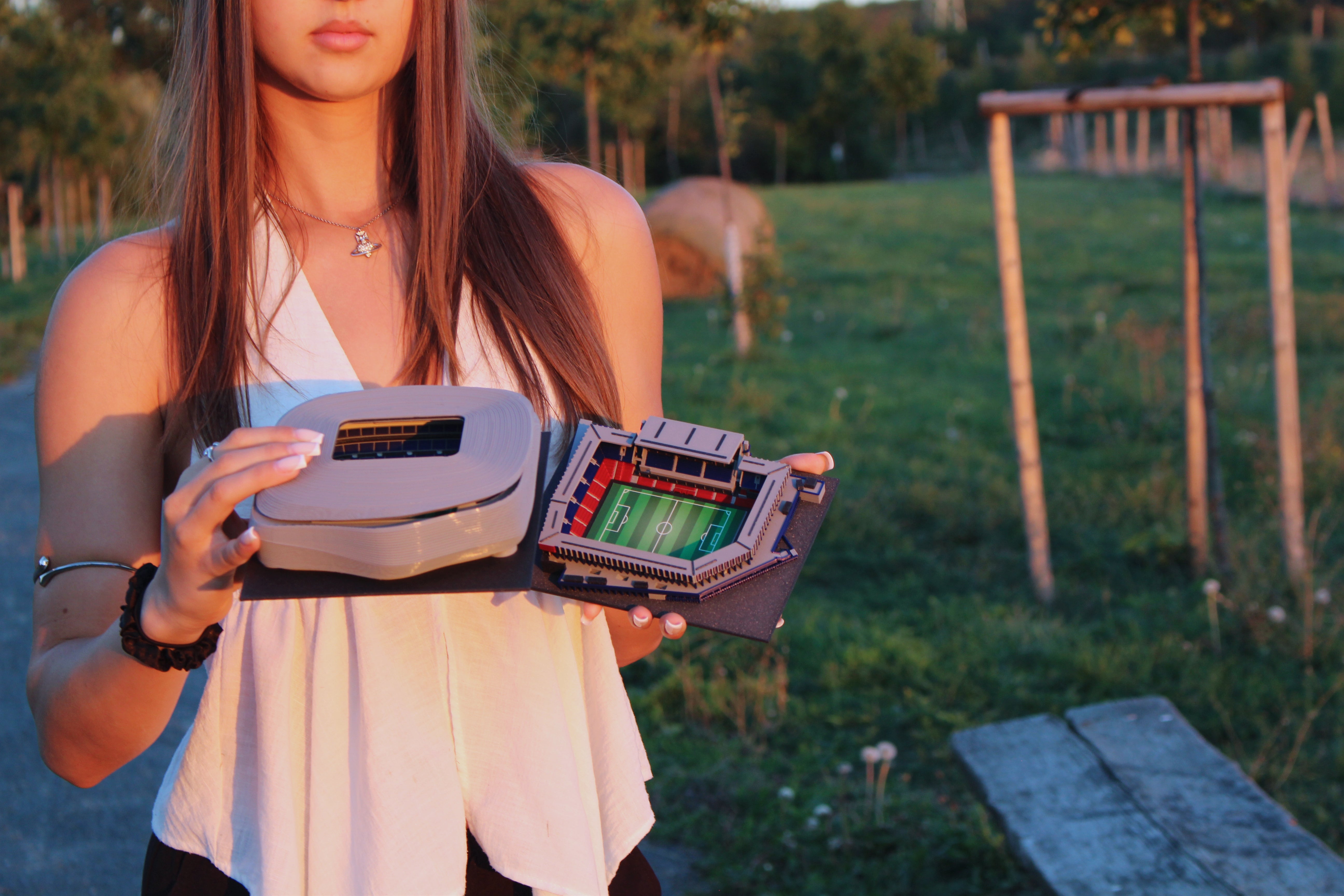Santiago Bernabéu and Letná stadium models held in a woman’s hands.